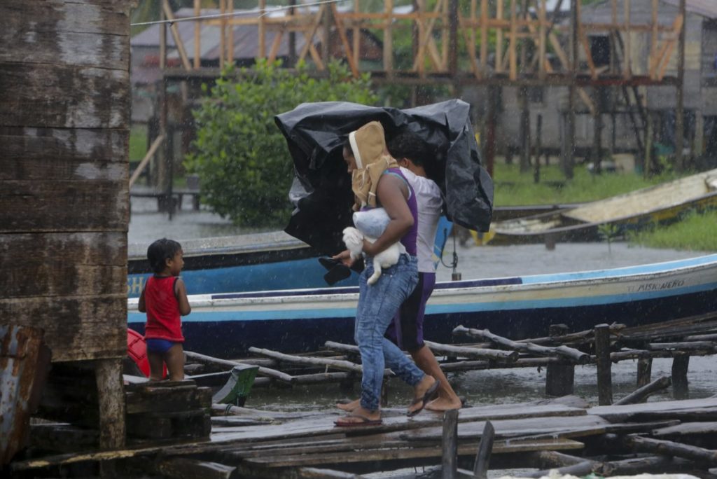 People carrying belongings and a pet leave their house at "El Canal" neighbourhood before Hurricane Otto hits Bluefields, Nicaragua on November 24, 2016. A powerful hurricane churned toward Nicaragua and Costa Rica with freight-train winds and heavy rains expected to trigger dangerous floods and mudslides. / AFP PHOTO / INTI OCON
