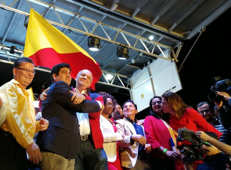 Carlos Alvarado y Rodolfo Piza se abrazan rodeados de figuras políticas del PAC y de otros partidos en la tarima ubicada en la plaza Roosevelt, en Montes de Oca