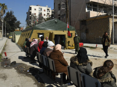 Sirios esperan en las afueras de un hospital de campaña de Bielorusia, donado, al gobierno para atender población al norte de la ciudad de Alepo. (AFP)